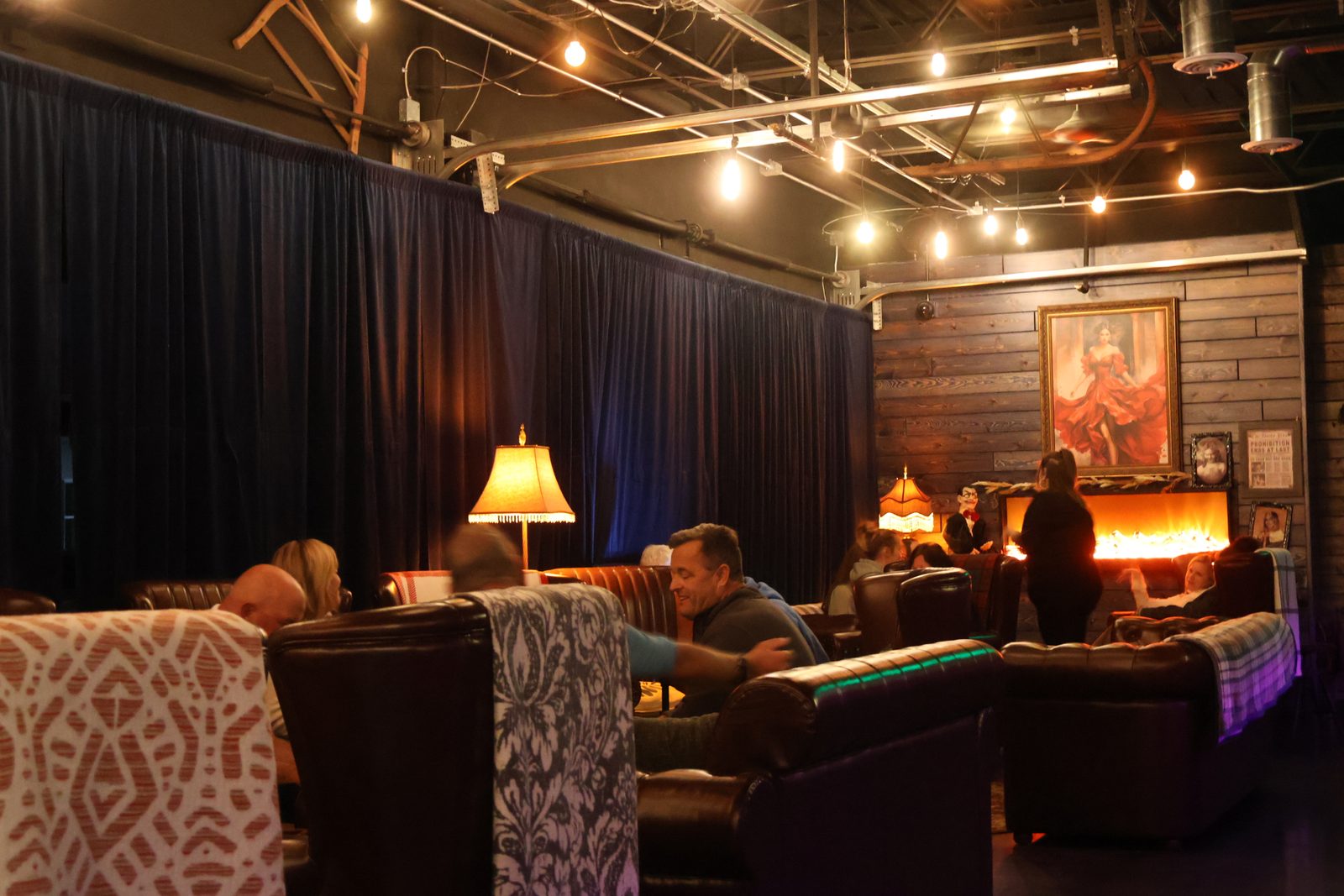 Guests socializing in The Laundry Room lounge with the fireplace lit