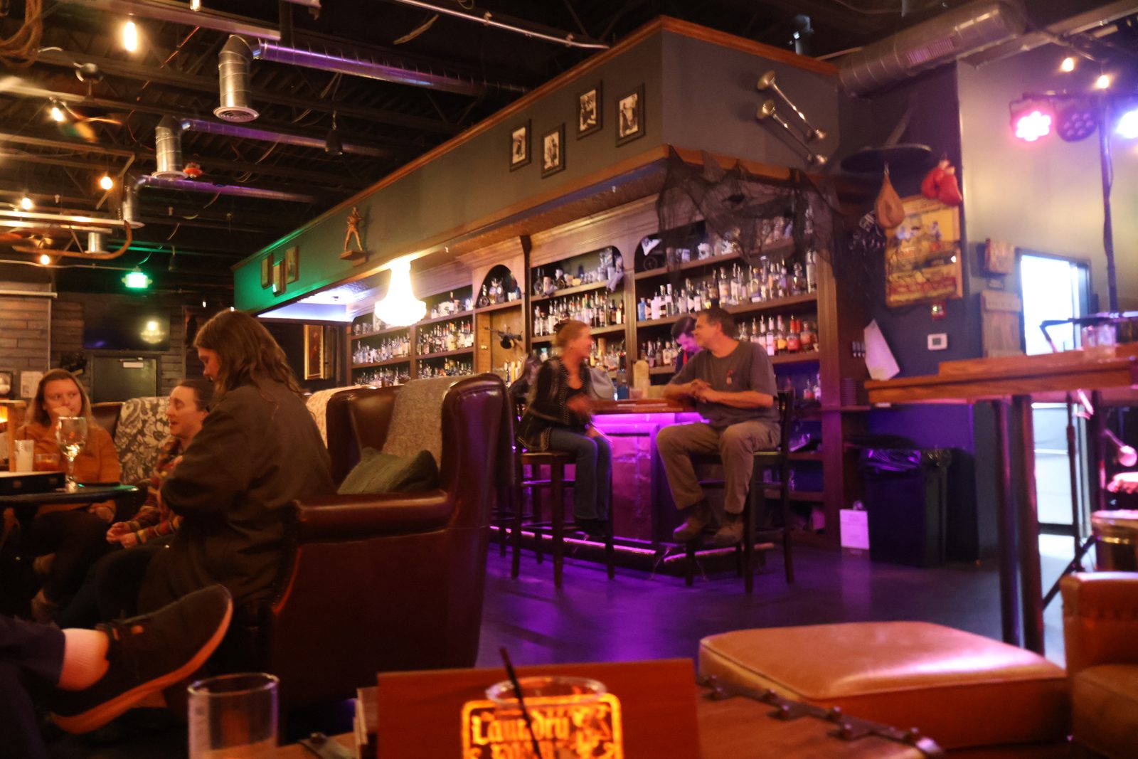 Guests seated and talking at the bar in The Laundry Room during the launch party
